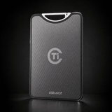 A sleek, rectangular titanium card case with a textured dark gray finish, featuring a silver 'Ti' logo and the brand name 'USELUCI' at the bottom. It is shown standing upright on a dark reflective surface against a black background.