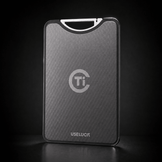 A sleek, rectangular titanium card case with a textured dark gray finish, featuring a silver 'Ti' logo and the brand name 'USELUCI' at the bottom. It is shown standing upright on a dark reflective surface against a black background.